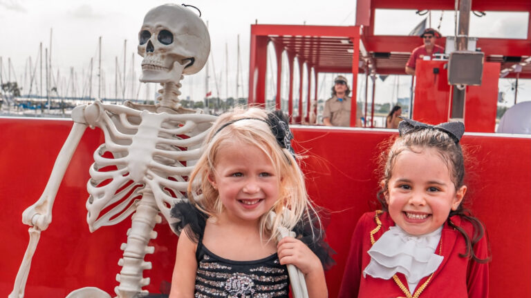 girls sitting next to a skeleton