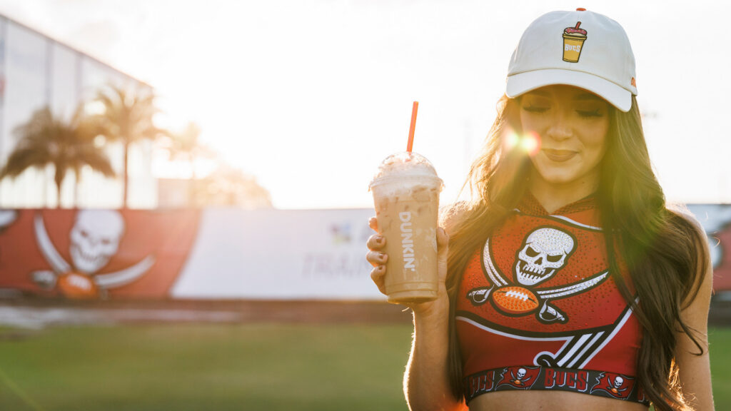 A person wearing a Dunkin Donuts by Tampa Bay Buccaneers hat